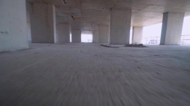 Camera moves around construction site of high building with view of city on sunny day. Apartment building under construction. Developer, real estate investment. concrete monolithic piles.