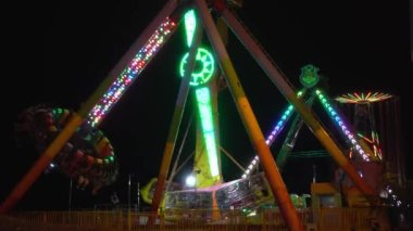 Dönen vagon şeklinde gece çekimi, insanlar çığlık atıyor ve eksen etrafında dönüyorlar. Özel bir yer, adil ya da festival. Saray şehri, korkunç açık hava atlıkarıncaları..