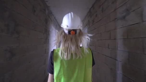 Młoda Szczupła Kobieta Białym Hełmie Zielonej Kurtce Spaceruje Korytarzem Budynku — Wideo stockowe