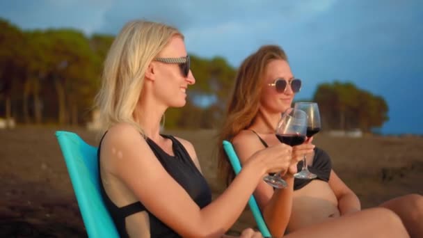 Två Sexiga Vita Kvinnor Svarta Glasögon Sitta Stolar Vid Havet — Stockvideo