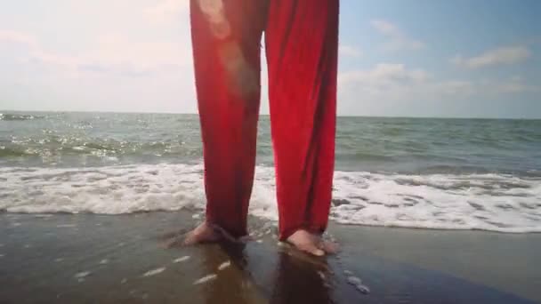 スーツ姿のサンタクロースはビーチや海に立っています 暑い日に砂とビーチでエキゾチックなクリスマスミーティング 休暇でリラックスする時間 足を閉じて — ストック動画