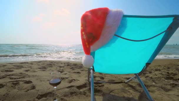 Glass Wine Chair Shizlong Santa Hat Beach Sand Backdrop Sunset — Stockvideo