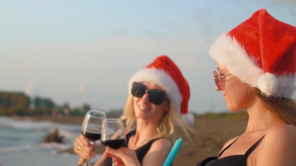 Happy Girls Bikinis Sit Chairs Celebrating Christmas Beach Drinking Wine — 图库视频影像