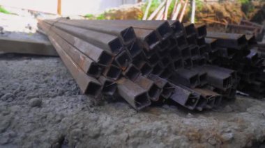 Metal parçaları. İnşaat teknolojileri. Metal çubuklar inşaat alanının deposunda depolanır. Depoda ya da şantiyede kare inşaat demiri.