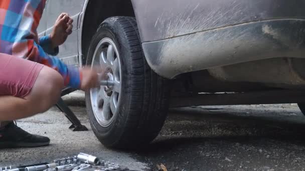 Homem Desaperta Roda Carro Sobre Doncrat Para Substituir Pneu Perfurado — Vídeo de Stock