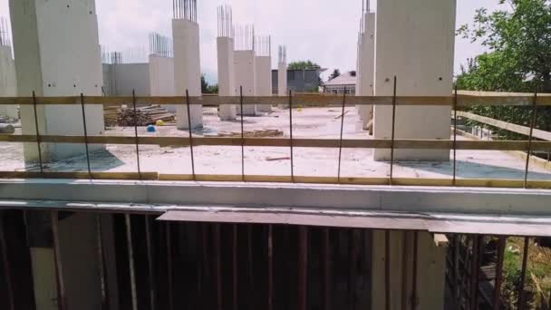 ドローンの観点から 上から建設現場のビュー 基礎と1階が建設され 突出した補強を持つモノリシックな柱の建設 開発者 都市住宅 — ストック動画