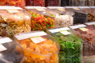 Dükkandaki plastik kaplarda çeşitli kurutulmuş meyveler.