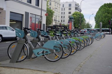 Paris, France - May 29, 2022: Row of Velib electric bicycles for public hire and share parked at Station Velib in street on Ile de la Jatte