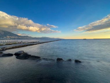 Gün batımında hareket bulanık dalgaları ve güzel renkleri olan Kalamata plajı. Kalamata, Messenia, Yunanistan