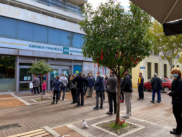 KALAMATA, GREECE - Vatandaşlar Corona virüs dönemi sırasında Kalamata şehrinin merkezindeki Aristomenous Meydanı 'ndaki Ethniki bankasının önünde otomatik veznedar (ATM) kullanmak için sıraya girdiler.