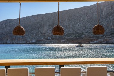 Modern dekorasyon, rahatlatıcı bir sandalyesi ve yaz aylarında Yunan denizi manzaralı ahşap mobilyaları olan asgari tarz..