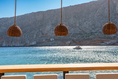 Modern dekorasyon, rahatlatıcı bir sandalyesi ve yaz aylarında Yunan denizi manzaralı ahşap mobilyaları olan asgari tarz..