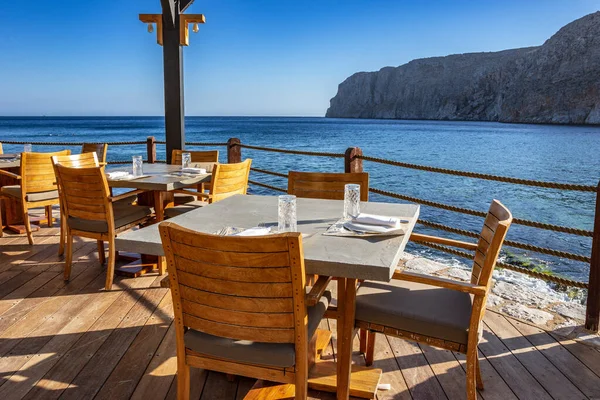 Modern dekorasyon, rahatlatıcı bir sandalyesi ve yaz aylarında Yunan denizi manzaralı ahşap mobilyaları olan asgari tarz..