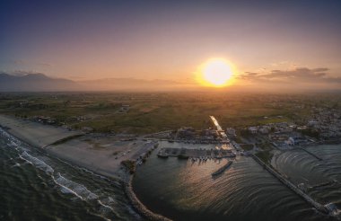 Katerini Marina 'sı, Pieria. Olimpiyat sahili yakınlarındaki sahil kenti Paralia Katerini 'ye bakın. Deniz taşlarının hava manzarası, küçük körfezde balıkçı tekneleri ve gemiler, gün batımında şehir eğlencesi..