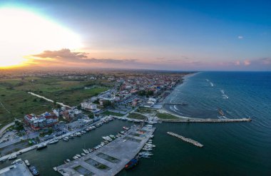 Katerini Marina 'sı, Pieria. Olimpiyat sahili yakınlarındaki sahil kenti Paralia Katerini 'ye bakın. Deniz taşlarının hava manzarası, küçük körfezde balıkçı tekneleri ve gemiler, gün batımında şehir eğlencesi..