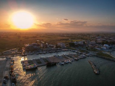 Katerini Marina 'sı, Pieria. Olimpiyat sahili yakınlarındaki sahil kenti Paralia Katerini 'ye bakın. Deniz taşlarının hava manzarası, küçük körfezde balıkçı tekneleri ve gemiler, gün batımında şehir eğlencesi..