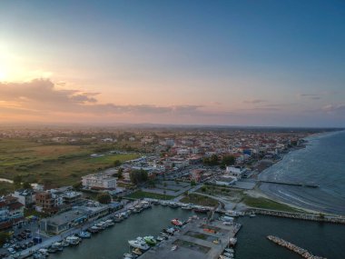 Katerini Marina 'sı, Pieria. Olimpiyat sahili yakınlarındaki sahil kenti Paralia Katerini 'ye bakın. Deniz taşlarının hava manzarası, küçük körfezde balıkçı tekneleri ve gemiler, gün batımında şehir eğlencesi..