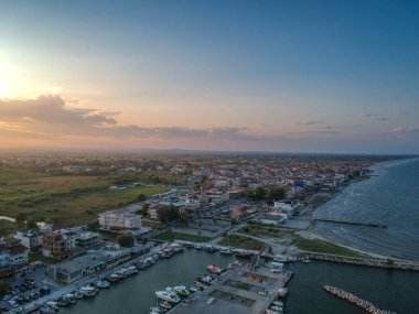 Katerini Marina 'sı, Pieria. Olimpiyat sahili yakınlarındaki sahil kenti Paralia Katerini 'ye bakın. Deniz taşlarının hava manzarası, küçük körfezde balıkçı tekneleri ve gemiler, gün batımında şehir eğlencesi..