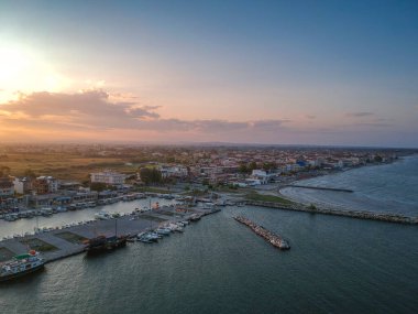 Katerini Marina 'sı, Pieria. Olimpiyat sahili yakınlarındaki sahil kenti Paralia Katerini 'ye bakın. Deniz taşlarının hava manzarası, küçük körfezde balıkçı tekneleri ve gemiler, gün batımında şehir eğlencesi..