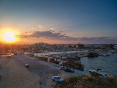 Katerini Marina 'sı, Pieria. Olimpiyat sahili yakınlarındaki sahil kenti Paralia Katerini 'ye bakın. Deniz taşlarının hava manzarası, küçük körfezde balıkçı tekneleri ve gemiler, gün batımında şehir eğlencesi..