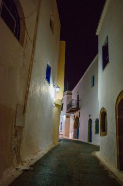 Geceleri Chora köyünün sokaklarında yürüyen insanların olduğu mimari binalar. Kythera adasındaki pitoresk Chora köyünün şehir fotoğrafçılığı.