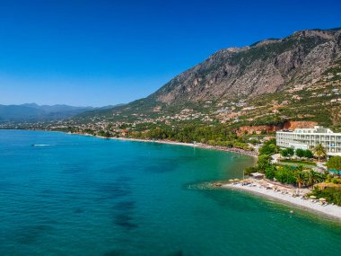 Yunanistan 'ın Kalamata kenti yakınlarındaki Kato verga sahil kasabasındaki Almyros plajında yüzen turistler yaz tatillerinin keyfini çıkarıyorlar.