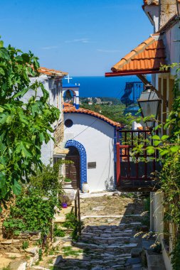 Yunanistan 'ın Alonissos adasındaki Chora köyünden güzel bir manzara. Dar kaldırımlı yolları ve renkli evleri olan geleneksel mimari binalar.