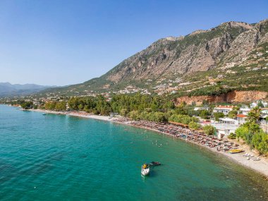 Yunanistan 'ın Kalamata kenti yakınlarındaki Kato verga sahil kasabasındaki Almyros plajında yüzen turistler yaz tatillerinin keyfini çıkarıyorlar.