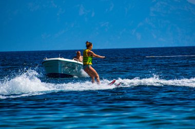 Woman enjoy waterski at Koukounaries beach in Skiathos island, Sporades, Greece