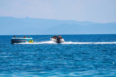 Turistler, Yunanistan 'ın Sporades adasındaki Koukounaries plajında şişirilebilir gezintilerin keyfini çıkarıyorlar