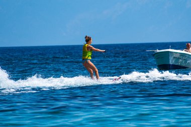 Woman enjoy waterski at Koukounaries beach in Skiathos island, Sporades, Greece
