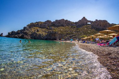 The beautiful pebbled beach of Chalkos in Kythera. Amazing scenery with crystal clear water and a small rocky gulf in Kythera island against a deep blue summer sky