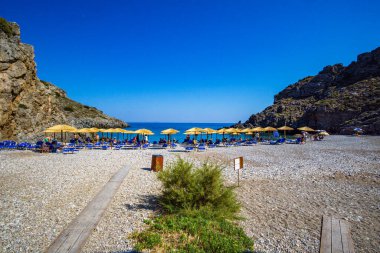 The beautiful pebbled beach of Chalkos in Kythera. Amazing scenery with crystal clear water and a small rocky gulf in Kythera island against a deep blue summer sky