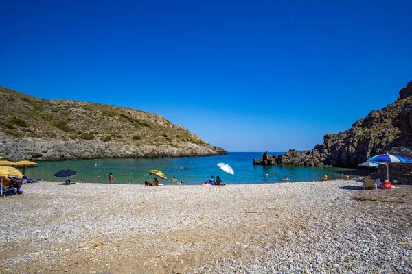 Kythera 'daki Chalkos' un güzel çakıl taşlı plajı. Kristal berrak su ve Kythera adasında küçük kayalık bir körfez ile harika bir manzara derin mavi bir yaz gökyüzüne karşı.