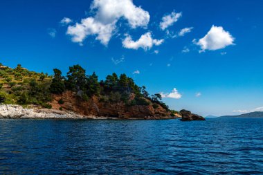 Tekne gezisi sırasında Kokkinokastro sahilinin yakınındaki doğu Alonissos adasının sahil manzarası. Alonissos Adası, Sporades, Yunanistan