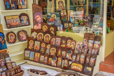 Urban view of Tinos island with narrow cobbled Streets and gift shops selling Religious souvenirs shops near Panagia Evangelistria church, Tinos, Cyclades, Aegean Sea, Greece