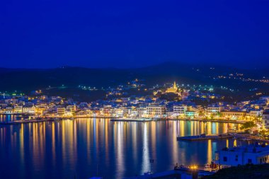 Tinos şehrinin gece görüşü. Panagia 'nın ünlü kilisesi, Bakire Meryem, geceleri aydınlanıyor. Tinos Adası Yunanistan.