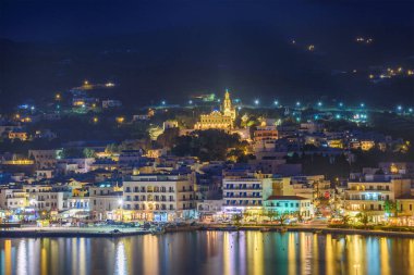 Tinos şehrinin gece görüşü. Panagia 'nın ünlü kilisesi, Bakire Meryem, geceleri aydınlanıyor. Tinos Adası Yunanistan.
