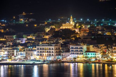 Night long exposure view of Tinos town. Centered the famous church of Panagia, Virgin Mary, illuminated at night. Tinos island Greece.