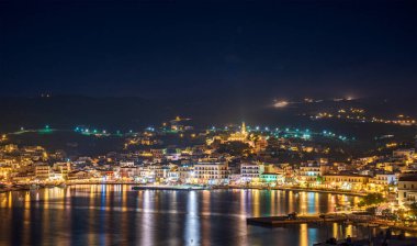 Tinos şehrinin gece görüşü. Panagia 'nın ünlü kilisesi, Bakire Meryem, geceleri aydınlanıyor. Tinos Adası Yunanistan.