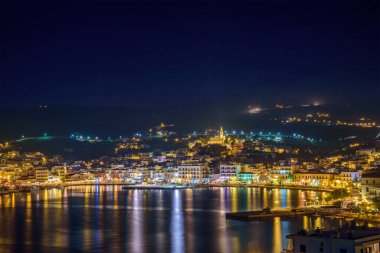 Tinos şehrinin gece görüşü. Panagia 'nın ünlü kilisesi, Bakire Meryem, geceleri aydınlanıyor. Tinos Adası Yunanistan.