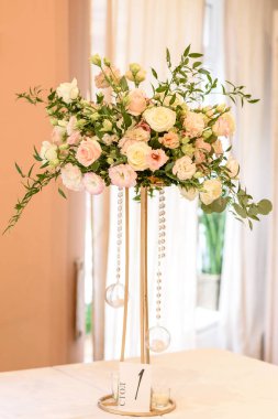 Düğün töreni için restoranda güzel çiçek kompozisyonları. Damat ve gelinin resmedildiği resmi tören