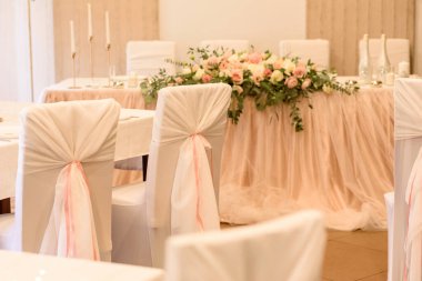 Düğün töreni için restoranda güzel çiçek kompozisyonları. Damat ve gelinin resmedildiği resmi tören