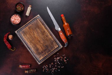 Mutfakta işyerinde, kesme tahtasının yanında baharatlar, tuz ve otlar var. Fırında pişirmek için bir tabak hazırlıyorum.