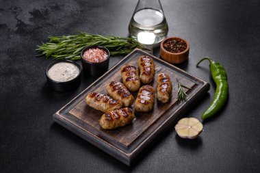 Izgara sosis ve arka planda bitki ve sebze. Izgara yemek, barbekü