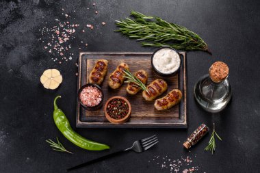 Izgara sosis ve arka planda bitki ve sebze. Izgara yemek, barbekü