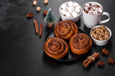 Baharatlı taze tarçınlı rulo ve siyah arka planda kakao. Cinnabon çörekleri. İsveç kahvaltısı.