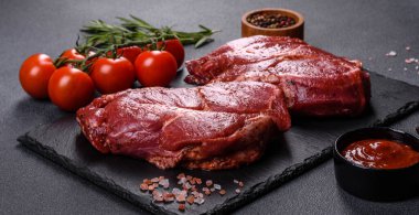 Siyah ahşap arka planda mükemmel çiğ biftek, yakın plan.