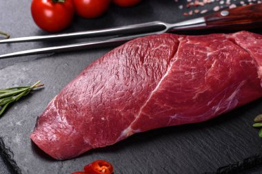 Çiğ Chuck rulo bifteği, otlar ve kesme tahtasında tuz. Gri arkaplan