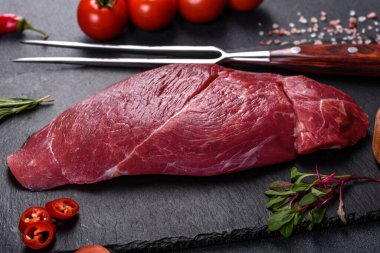 Çiğ Chuck rulo bifteği, otlar ve kesme tahtasında tuz. Gri arkaplan